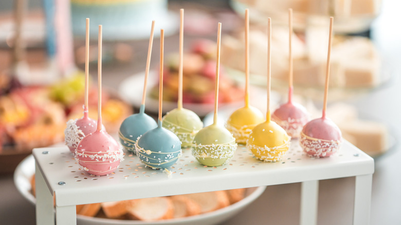 Ten cake pops in pink, blue, green, yellow, and mauve