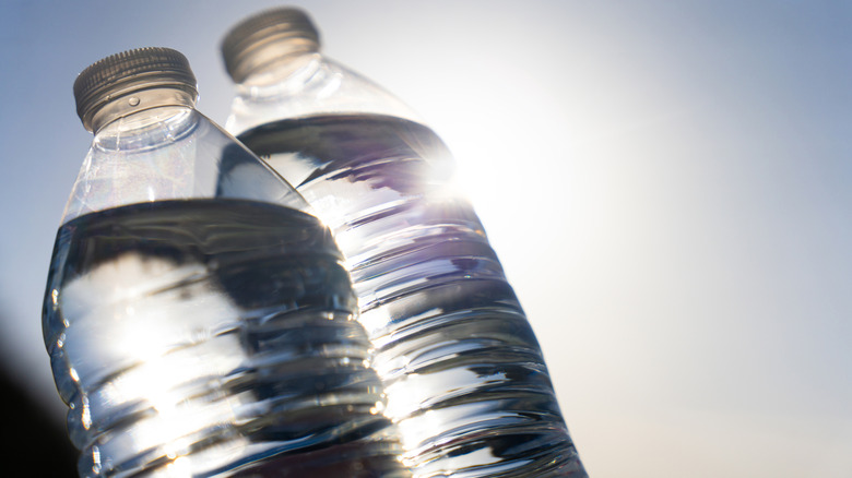 Two half-filled water bottles sitting in the sun