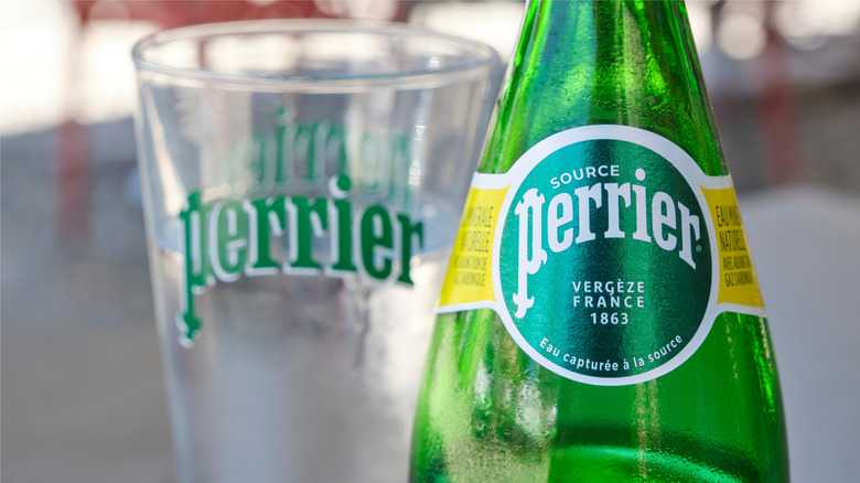 Bottle of Perrier next to an empty glass