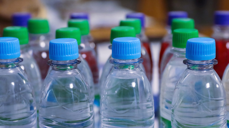 Water bottles arranged in rows with caps of different colors