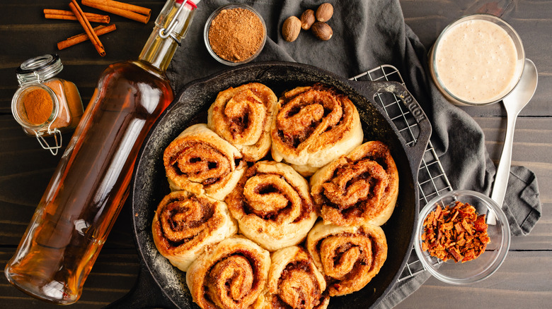 Bottle of bourbon next to a dish of cinnamon rolls