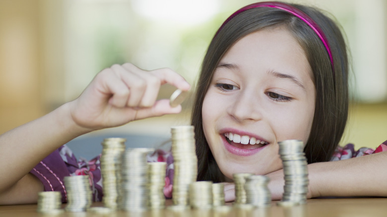child stacking coins