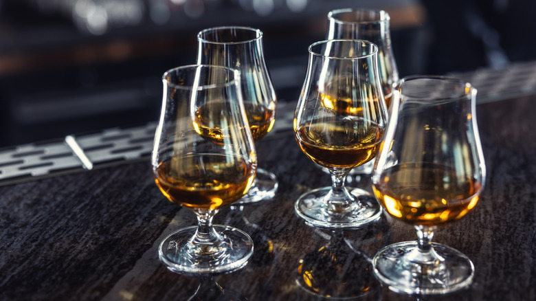 Five glasses of Cognac on a wooden surface