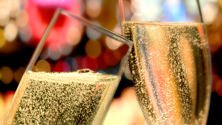 Two champagne flutes being bumped together at a toast