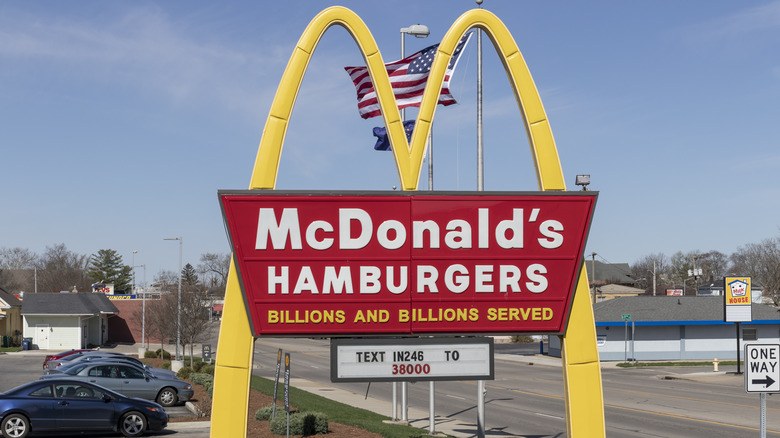 McDonald's Hamburgers golden arch sign next to a busy street