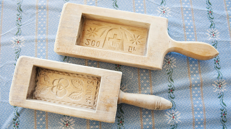 Two rectangular wooden butter molds on a blue patterned cloth