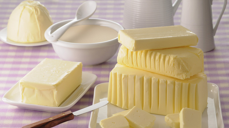 A variety of butter blocks shaped by different molds on a chequered table cloth