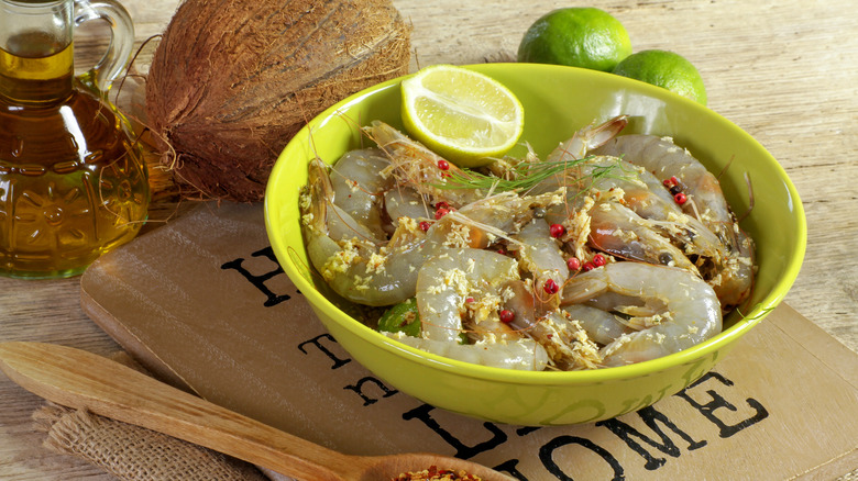 Raw shrimp in a bowl with fresh limes