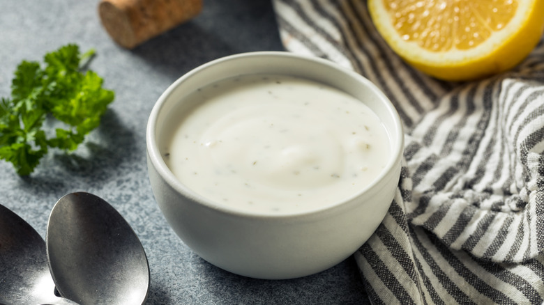 Ranch dressing sits in a bowl near a lemon