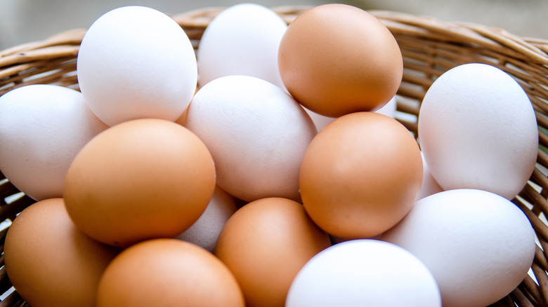 Wicker basket full of white and brown eggs