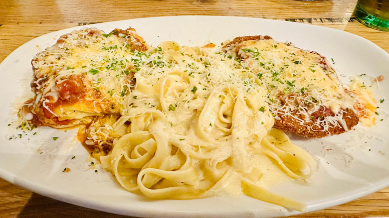 A plate of Olive Garden pasta and meats on a table