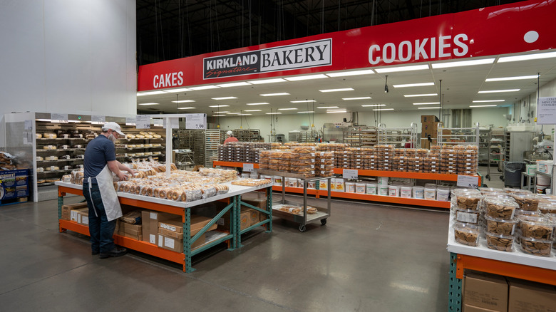 Costco bakery department with a worker stocking up on bagels