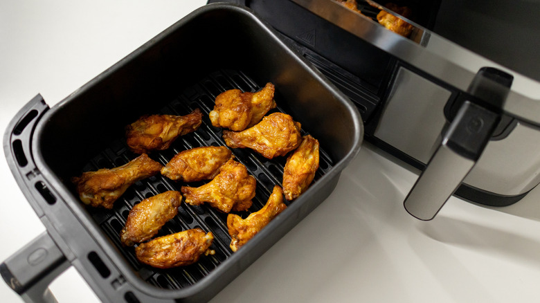 Cooked chicken wings in an air fryer basket