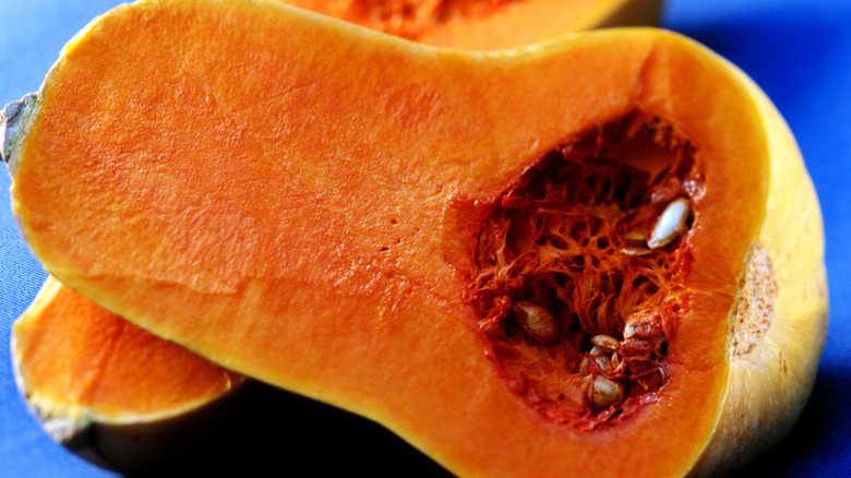 Halved butternut squash on a blue background