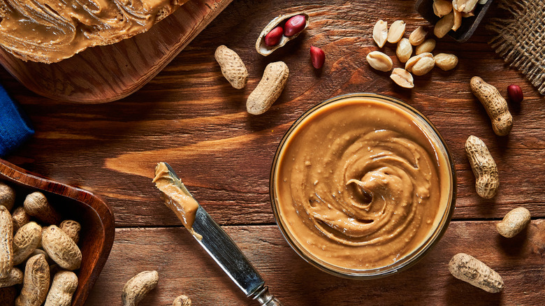 A smooth jar of peanut butter with a knife next to it