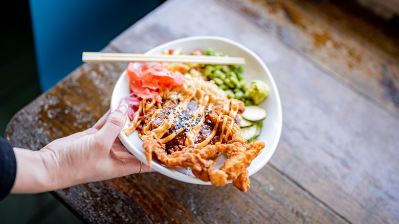 Tempura fried soft shell crab in a poke bowl with chopsticks