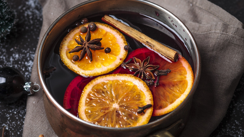 Star anise pods floating in a saucepan of mulled wine.