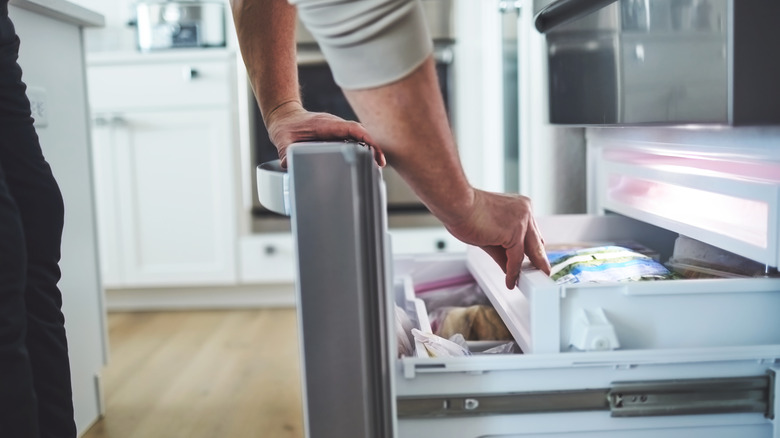 hands reaching in freezer