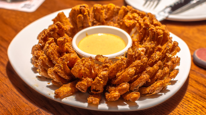 Bloomin' Onion with dipping sauce at a restaurant