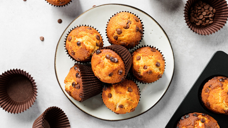 Chocolate chip muffins are piled on a plate