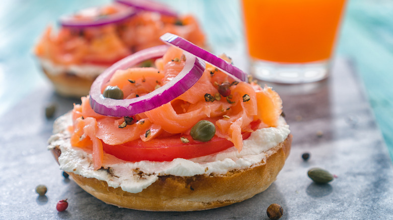 Half bagel with cream cheese, tomato, capers, red onion