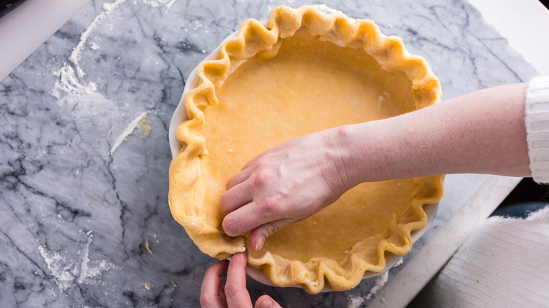 a person making pie crust