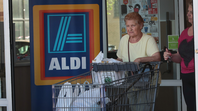 woman leaving Aldi with groceries