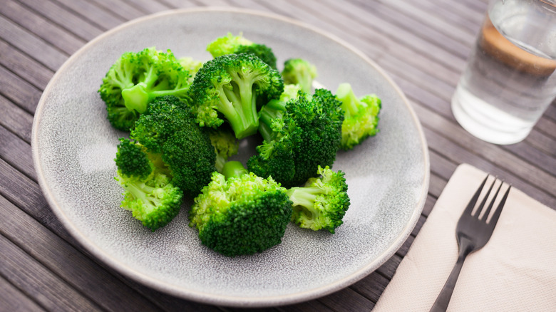 cooked broccoli florets on grey plate