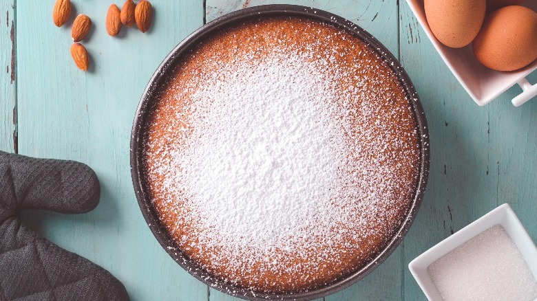 A round almond cake viewed from above, dusted with powdered sugar.