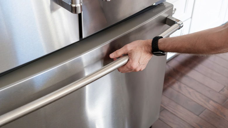 A man pulling open the freezer door