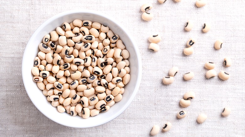 Black-eyed peas in bowl and spread on tablecloth