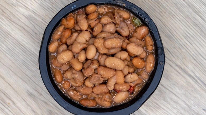 Cooked pinto beans in a black bowl