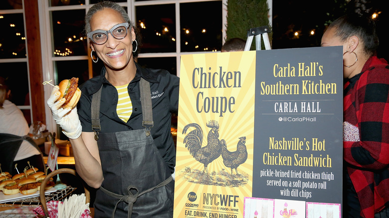 Carla Hall holds chicken sandwich