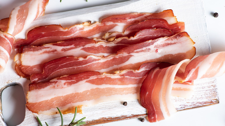 Bacon strips arranged on a white board