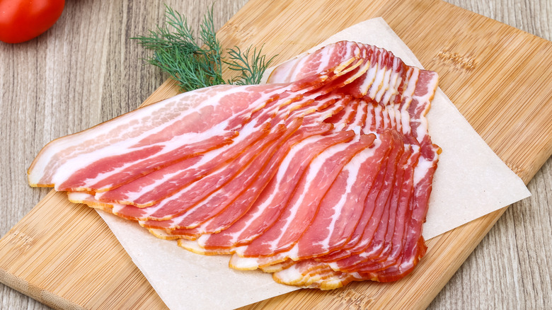 Slices of bacon on a wooden cutting board