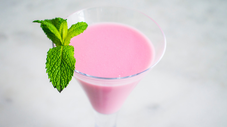 Pink squirrel in martini glass, garnished with mint.