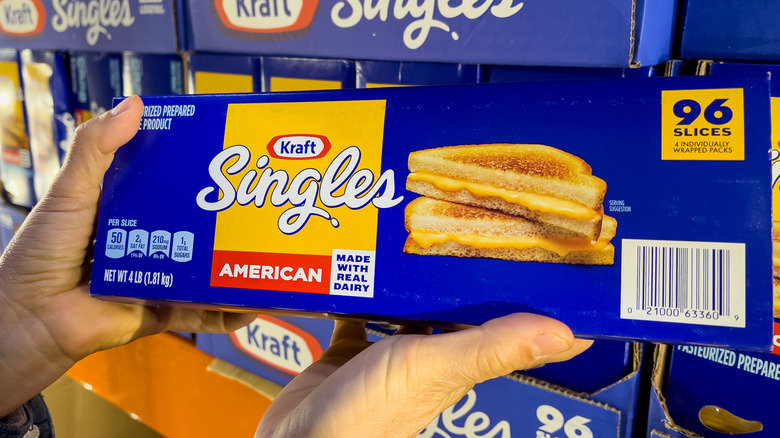 A person holding a packet of Kraft Singles.