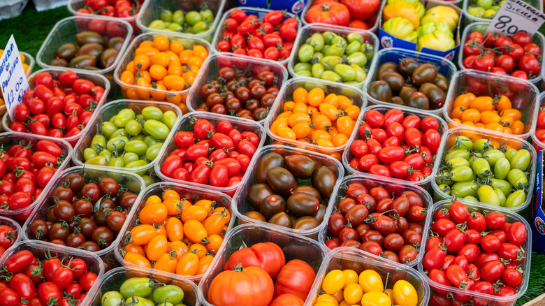 A display with different varieties of tomatoes in plastic punnets