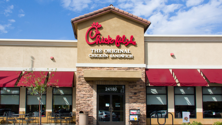 A chick-fil-A restaurant against a blue sky.