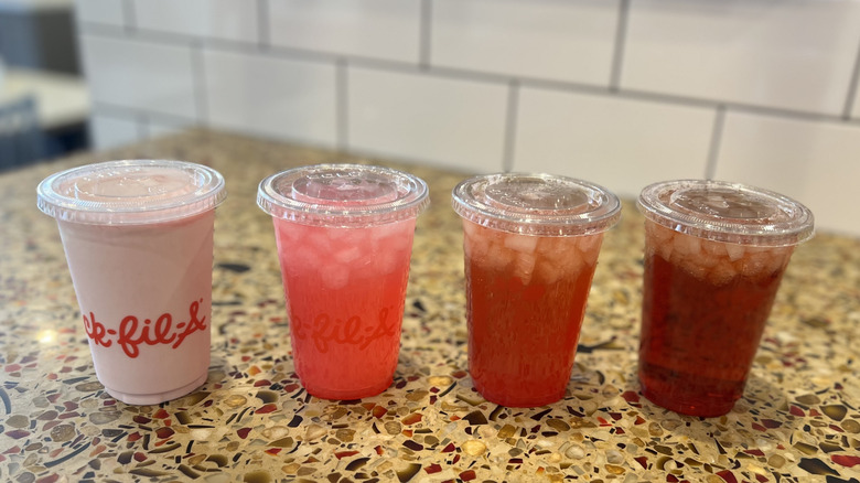 Four Pineapple Dragonfruit beverages are lined up on a counter.