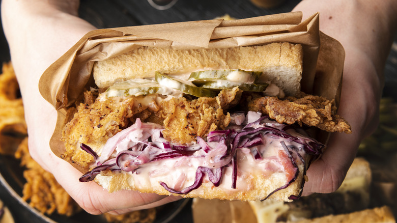 Person holding chicken sandwich