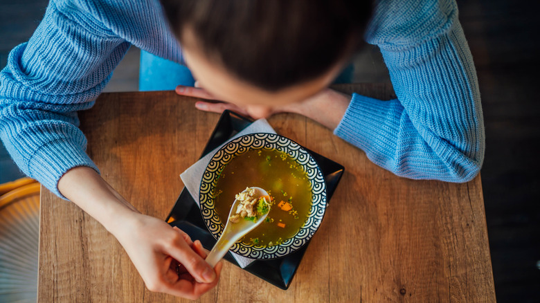 Person eating chicken soup