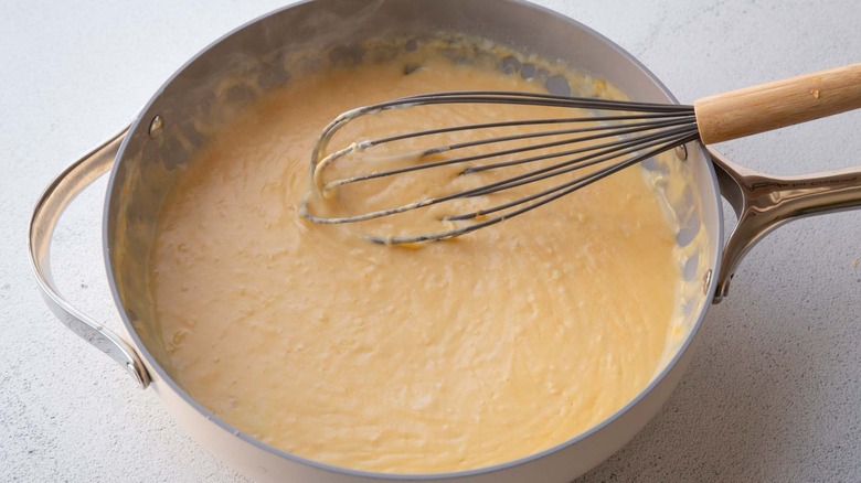 Cheese sauce and whisk in pan