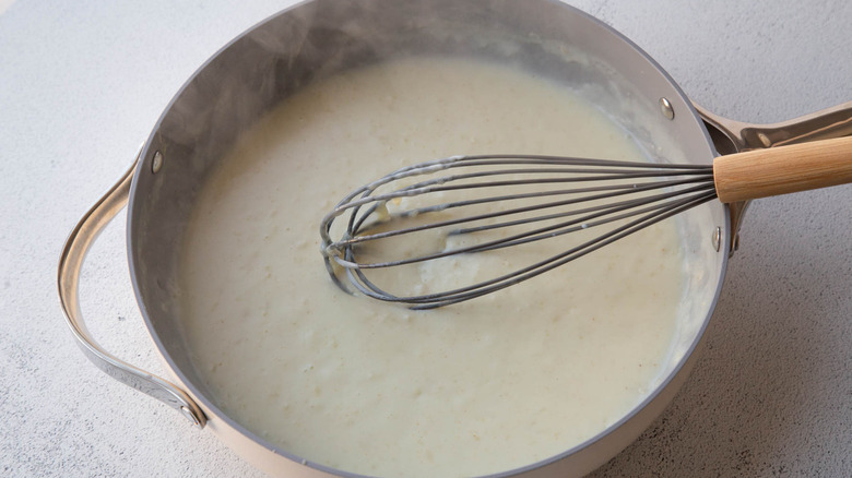 Creamy sauce and whisk in pan