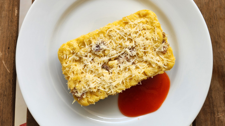 Loaf of macaroni on plate with red sauce