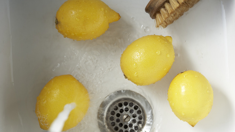 Four yellow lemons in the sink