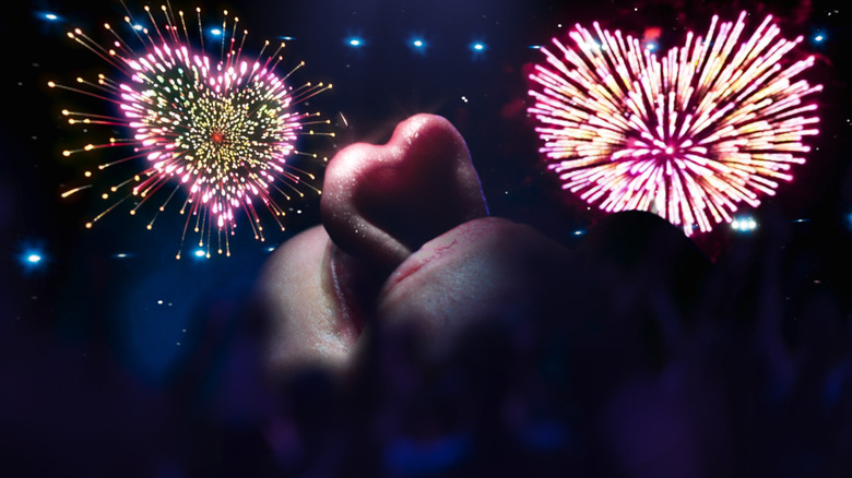 A person's tongue is shown in heart shape surrounded by fireworks