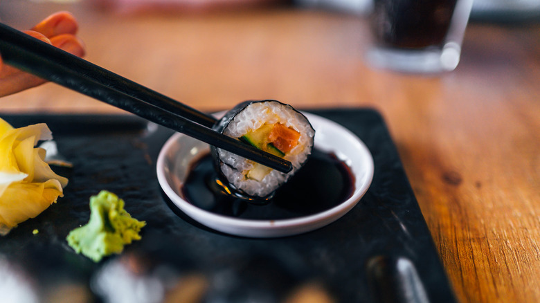 Dipping sushi in soy sauce