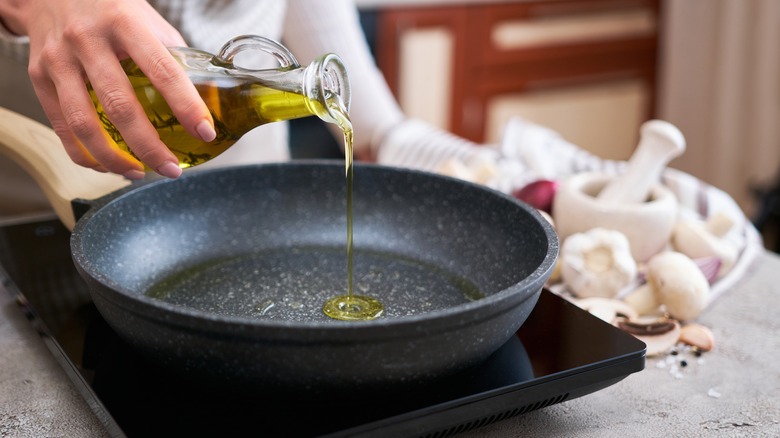 pouring oil into a frying pan