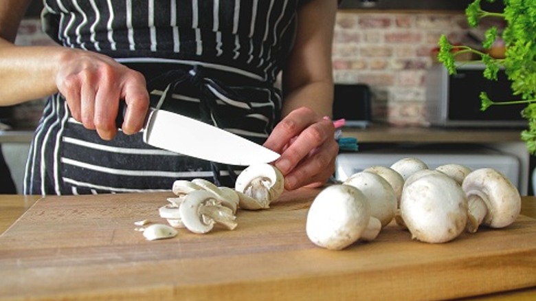 slicing mushrooms on cutting board